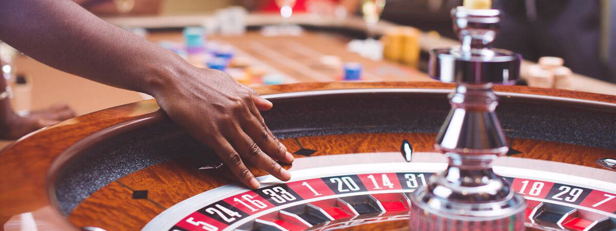 Beaming casa host pointing ahead in a bright play hall with betting and reels behind him denoting the BH 999 entry path for punters in Bangladesh